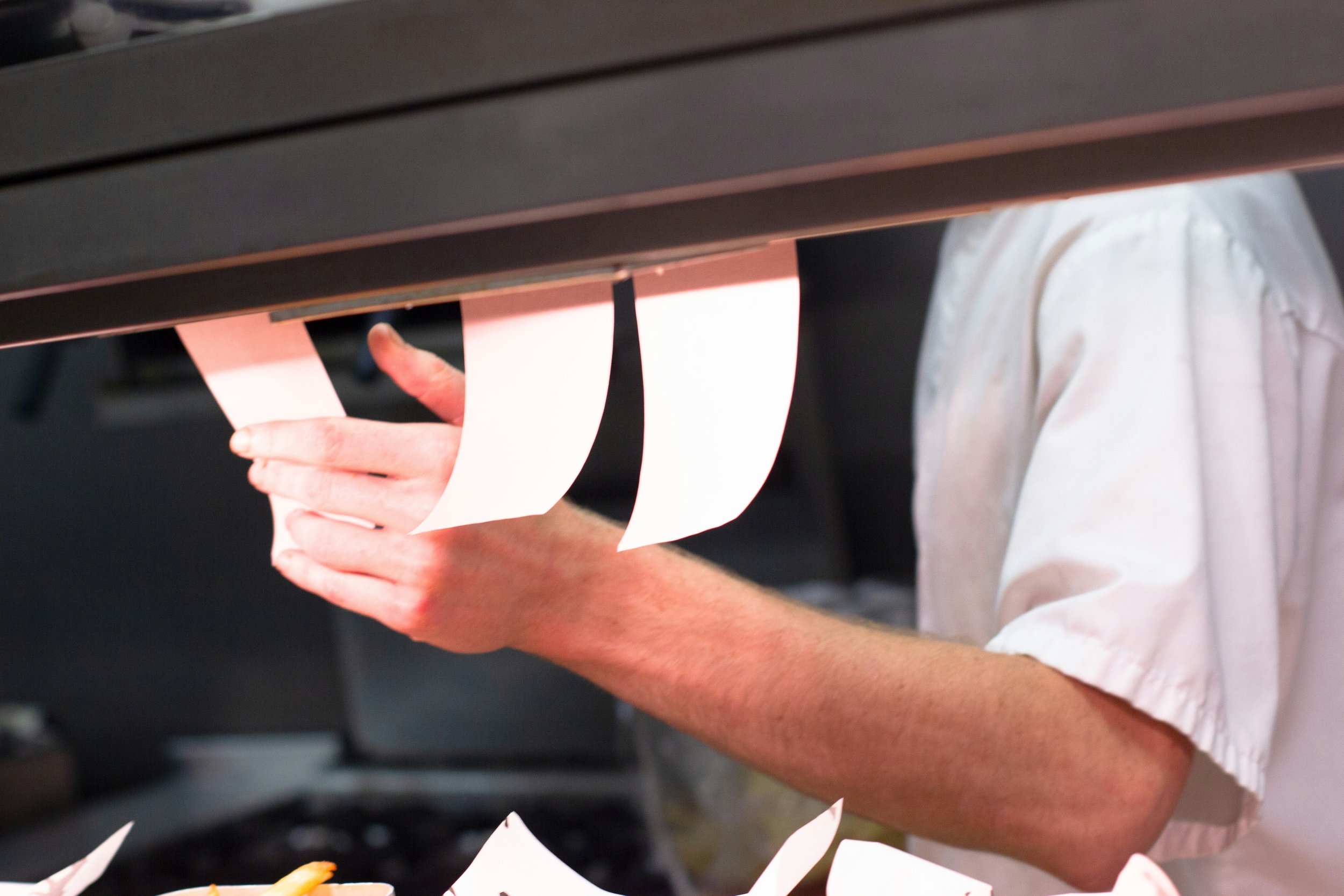 A chef organising orders at the kitchen pass