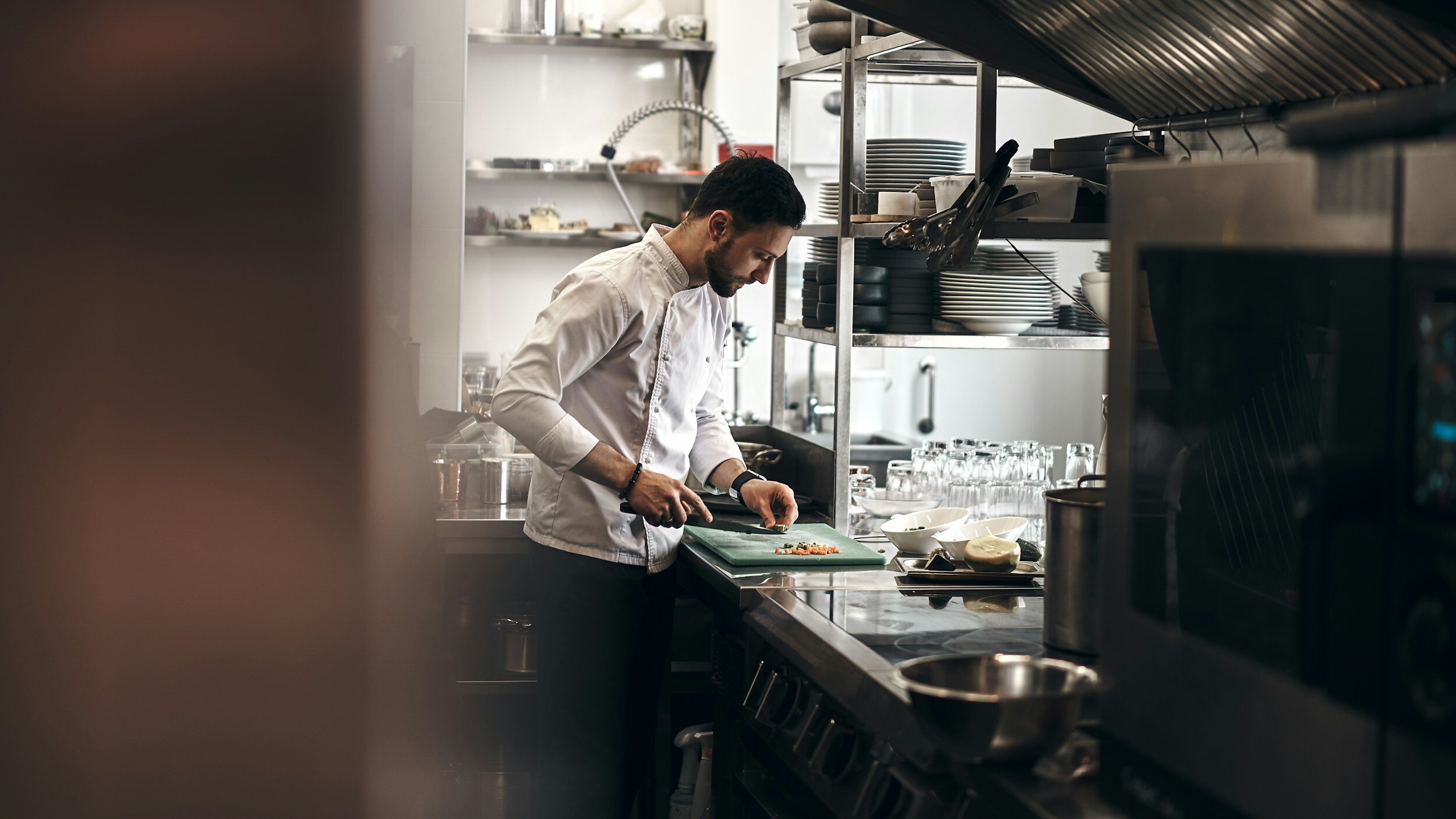 A chef carefully preparing ingredients in a professional kitchen